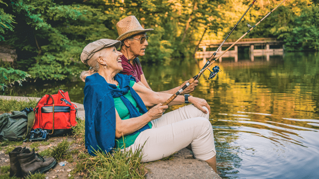 senior man and woman fishing in a stream