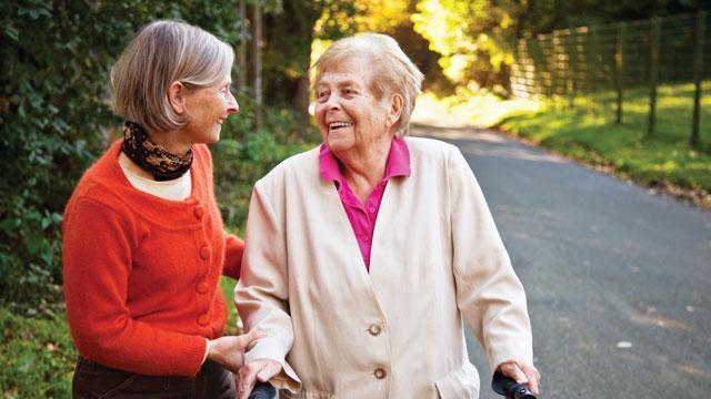 two senior women walking and chatting outdoors