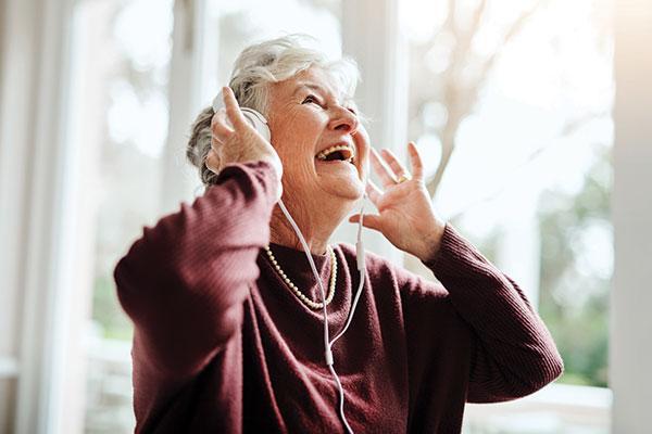senior woman listening to music through headphones