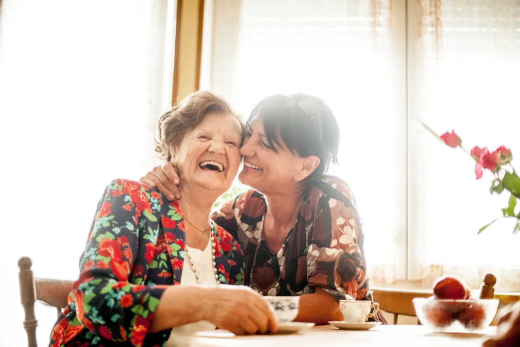 Senior Woman and Caregiver Having Coffee